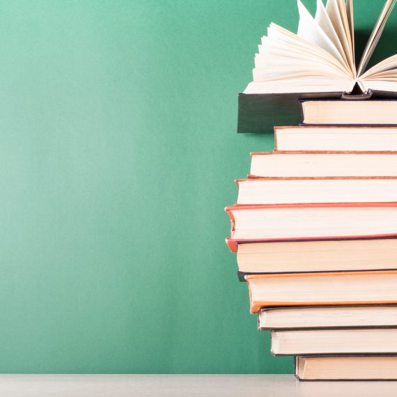 Open book, hardback books on wooden table. Education background. Back to school. Copy space for text